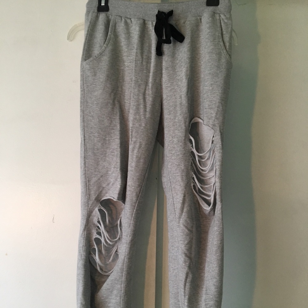Grey sweatpants with rips.